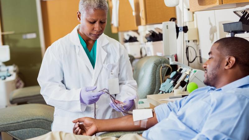 A healthcare professional draws blood from a patient.