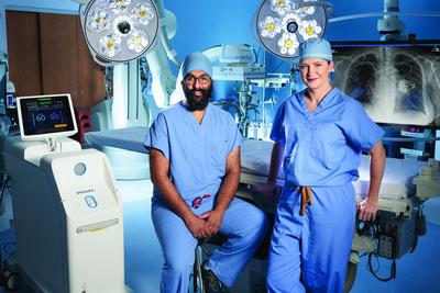 Doctors Sidhu and Harrison pose for a photo in a cardiac electrophysiology lab at MedStar Health.