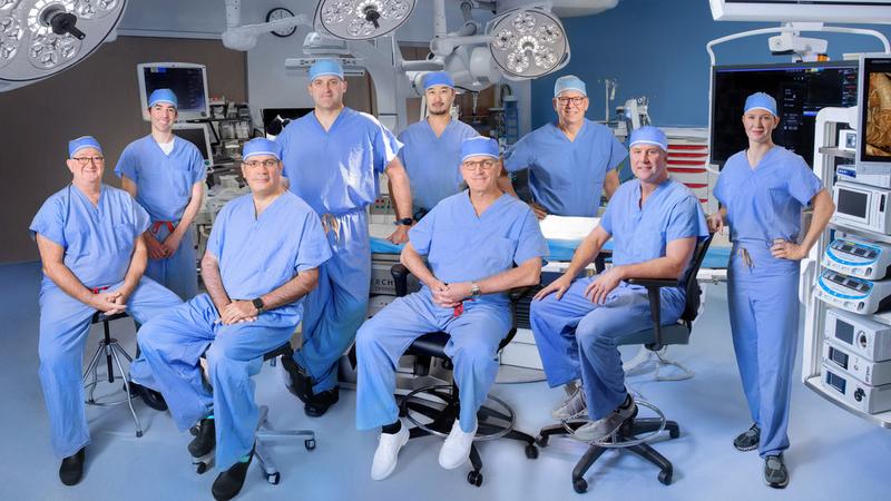 A team of cardiac surgeons from MedStar Health pose for a group photo in an operating room.