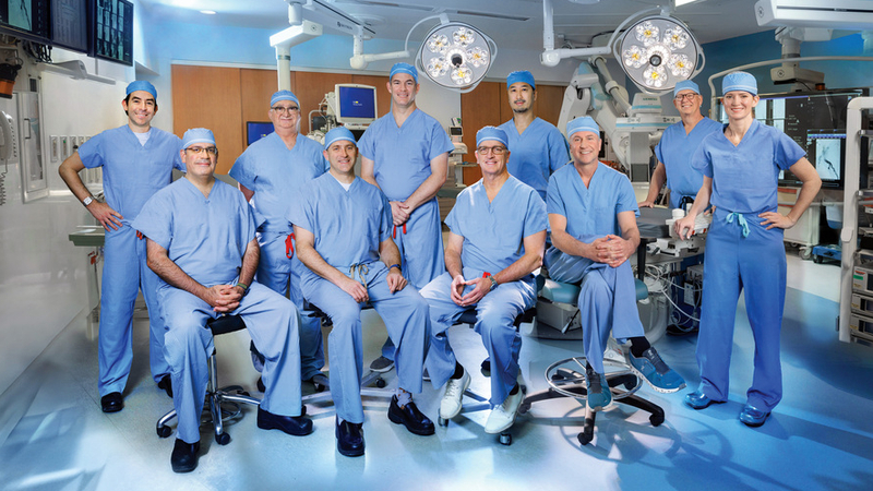 A team of cardiac surgeons from MedStar Health pose for a group photo in an operating room.