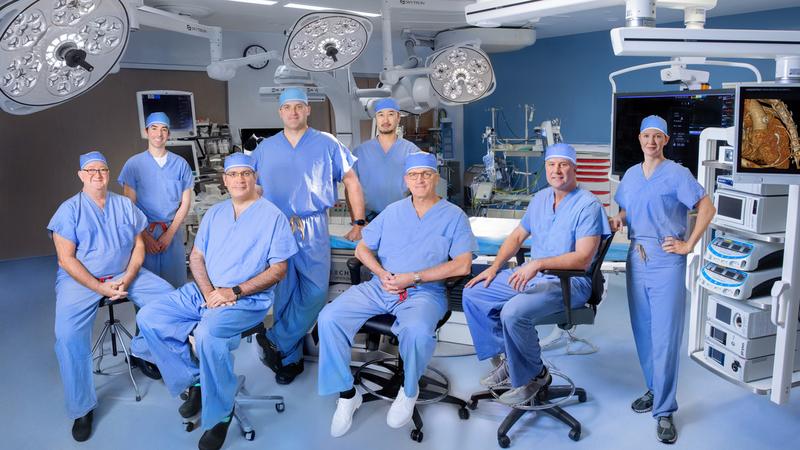 A team of cardiac surgeons from MedStar Health pose for a group photo in an operating room.