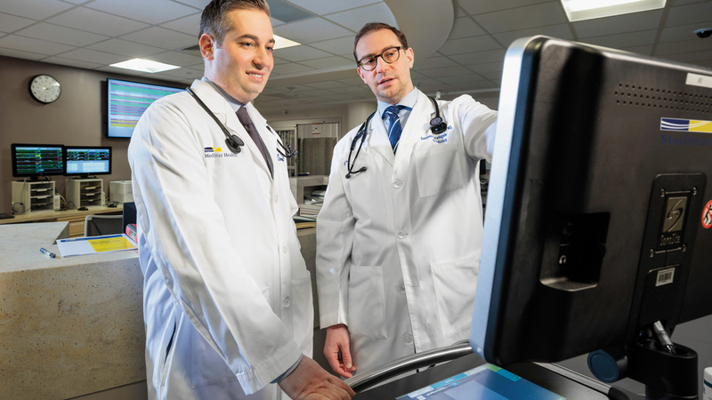 Doctors Benjamin Kenigserg and Alexander Papolos confer at a computer station at MedStar Washington Hospital Center.