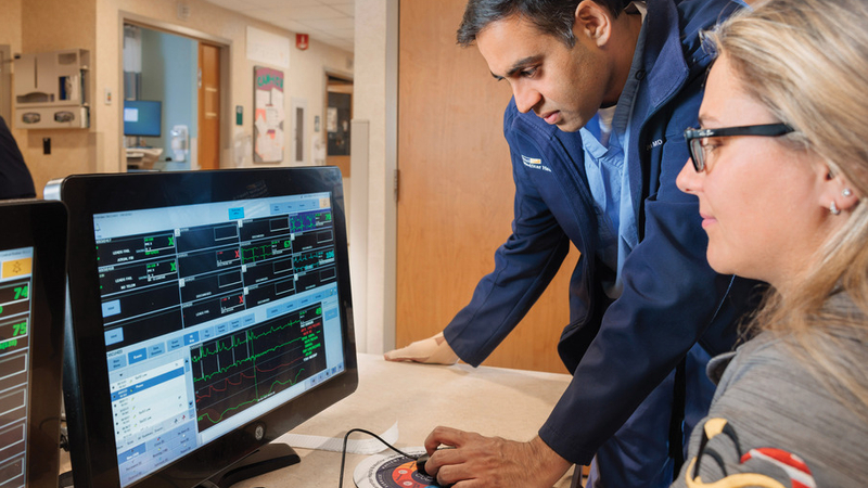 Dr. Nimish Shah looks at a computer monitoring system with another healthcare professional at MedStar Health.
