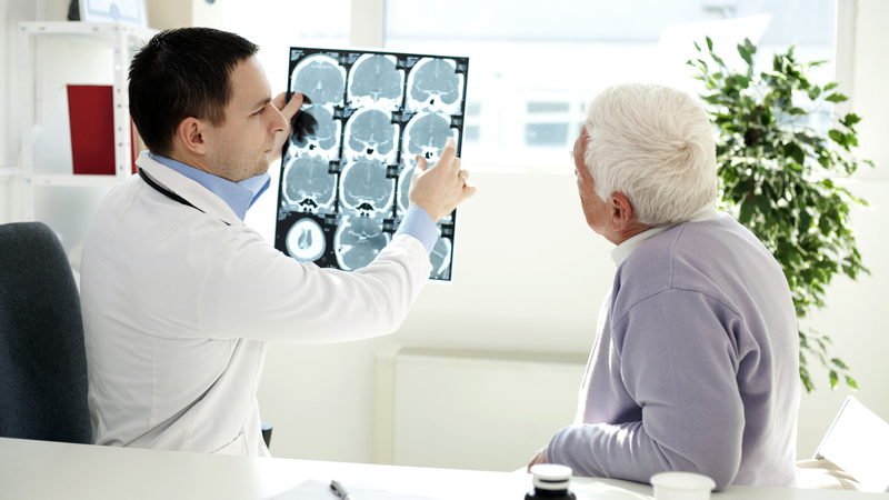 A neurologist reviews scans with a patient.