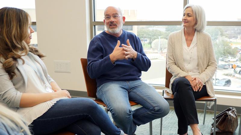 A man sits talks with his support group in a clinical setting.