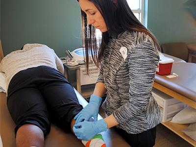 A medical professional gives a dry needling treatment to a patient.