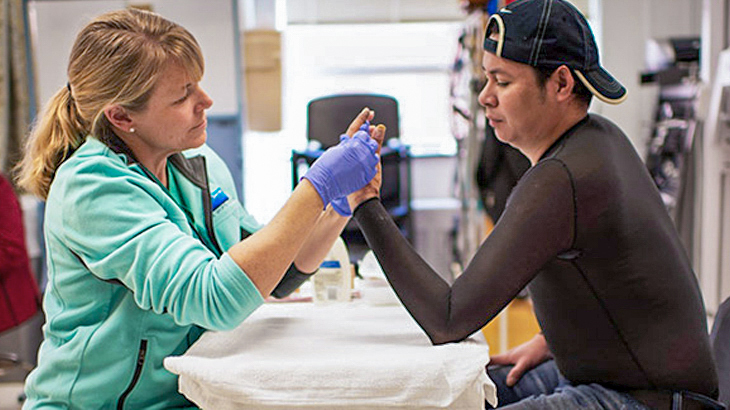 A burn therapist works with a patient to provide therapy to his hand at MedStar Health.