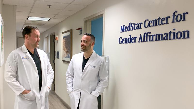 Dr. Andrew Hodge and Dr. Gabriel DelCorral have a conversation in the hallway of the MedStar Health Center for Gender Affirmation in Baltimore, Maryland.