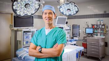 Dr Stanley Chia stands in an operating room with his arms folded at MedStar Health.