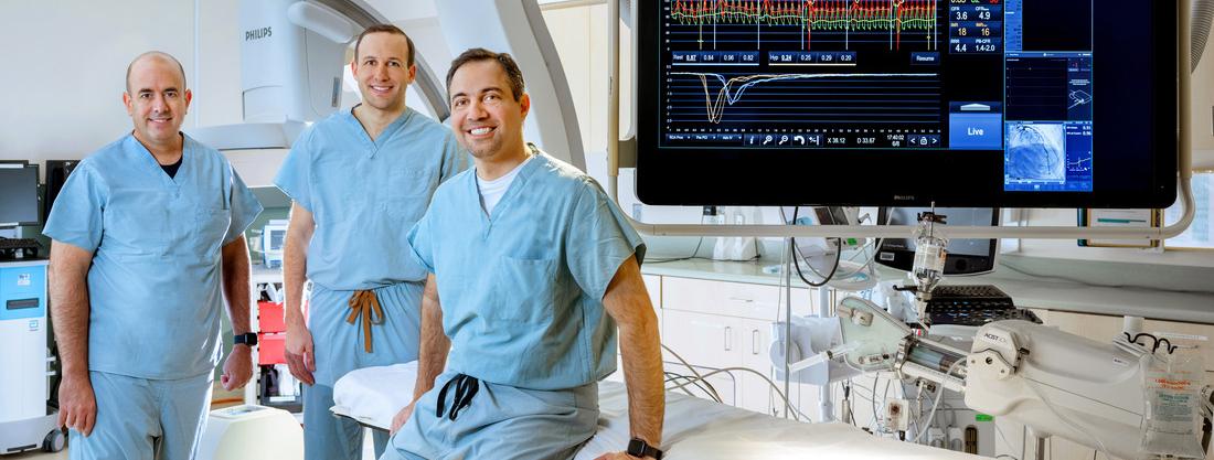 Doctors Itsik Ben-Dor, Brian Case and Hayder Hashim pose for a team photo in the cardiac catheterization lab at MedStar Washington Hospital Center.