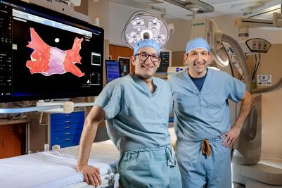 Doctors Hadadi and Thomiades pose for a photo in a cardiac electrophysiology suite at MedStar Health.
