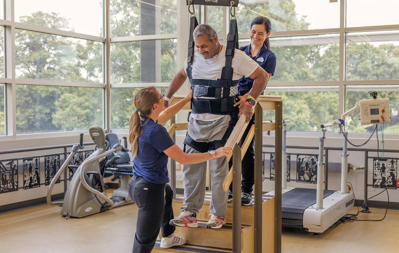Physical therapists work with a patient in the rehabilitation gym at MedStar National Rehabilitation Hospital.