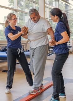 Physical therapists work with a patient in the rehabilitation gym at MedStar National Rehabilitation Hospital.