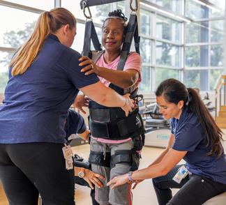 Physical therapists work with a patient in the rehabilitation gym at MedStar National Rehabilitation Hospital.
