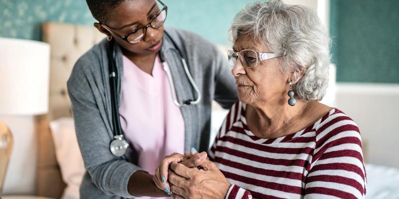 A nurse provides compassionate care for an elderly female patient.