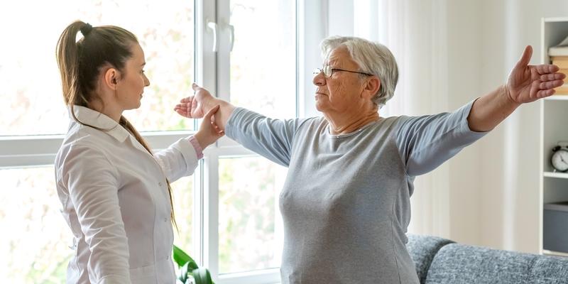 A neurorehabilitation specialist work with a patient during a therapy session.