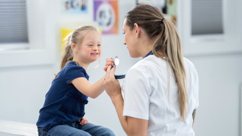 A doctor treats a pediatric downs syndrome patient.