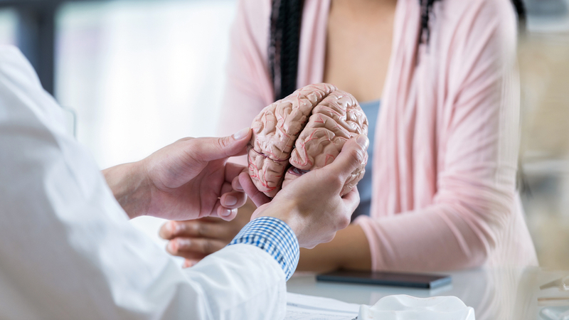 A doctor gives a high-five to a child patient in a clinical setting.