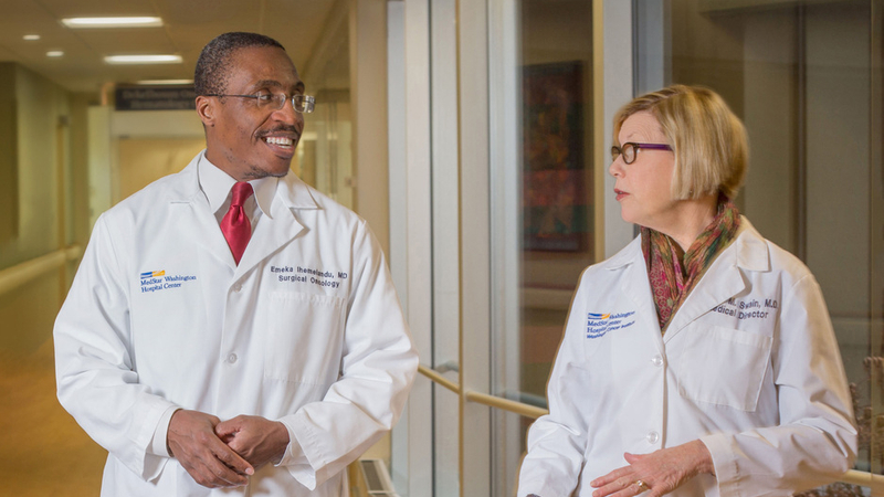 Doctors Ihemelandu and Swain talk while walking through the hallway at MedStar Washington Hospital Center.