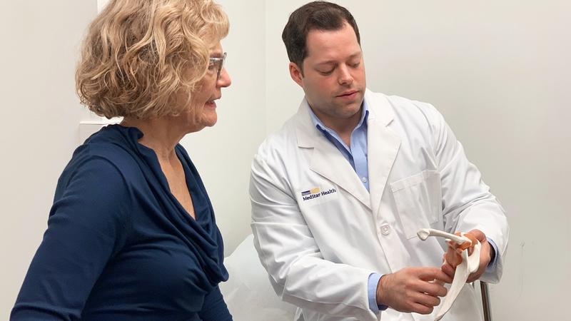 Dr Ryan Hoffman talks with a patient in a clinical setting.