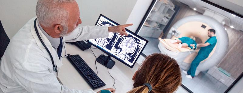 Doctors monitor a patient in an MRI scanner.