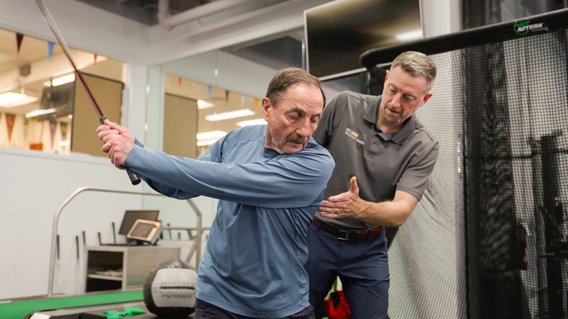 Justin Cooper works with a patient at MedStar Health golf medicine.