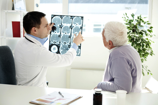 A neurologist reviews scans with a patient.