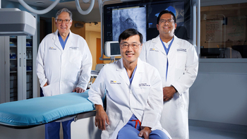 A team of interventional cardiologists from MedStar Unioin Memorial Hospital pose for a photo in an operating room.