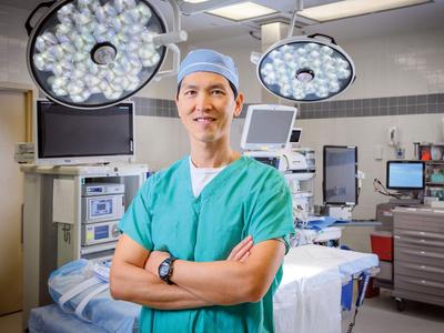 Dr Stanley Chia stands in an operating room with his arms folded at MedStar Health.