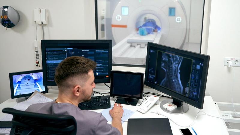 A diagnostic radiologist monitors while a patient undergoes diagnostic imaging scans.