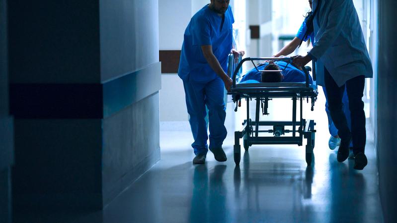 Healthcare professionals transport a patient in a hospital.