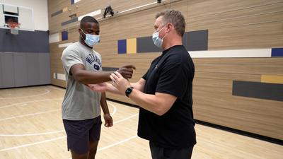 Lance Kelly works with professional tennis player Frances Tiafoe at a MedStar Health rehabilitation gym.