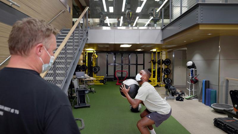 Lance Kelly works with professional tennis player Frances Tiafoe at a MedStar Health rehabilitation gym.