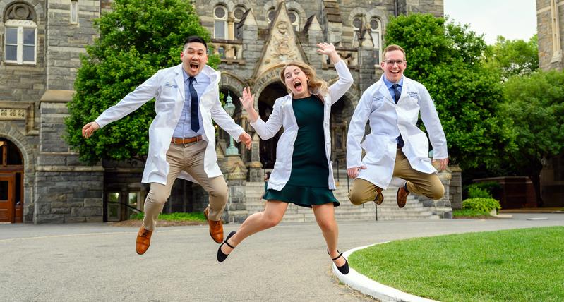 Fun, candid photo of 3 graduates from the Urology Residency Program at MedStar Health, jumping in the air.