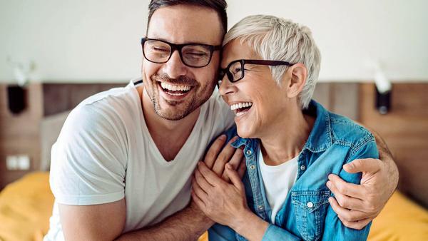 An adult son hugs his mother.